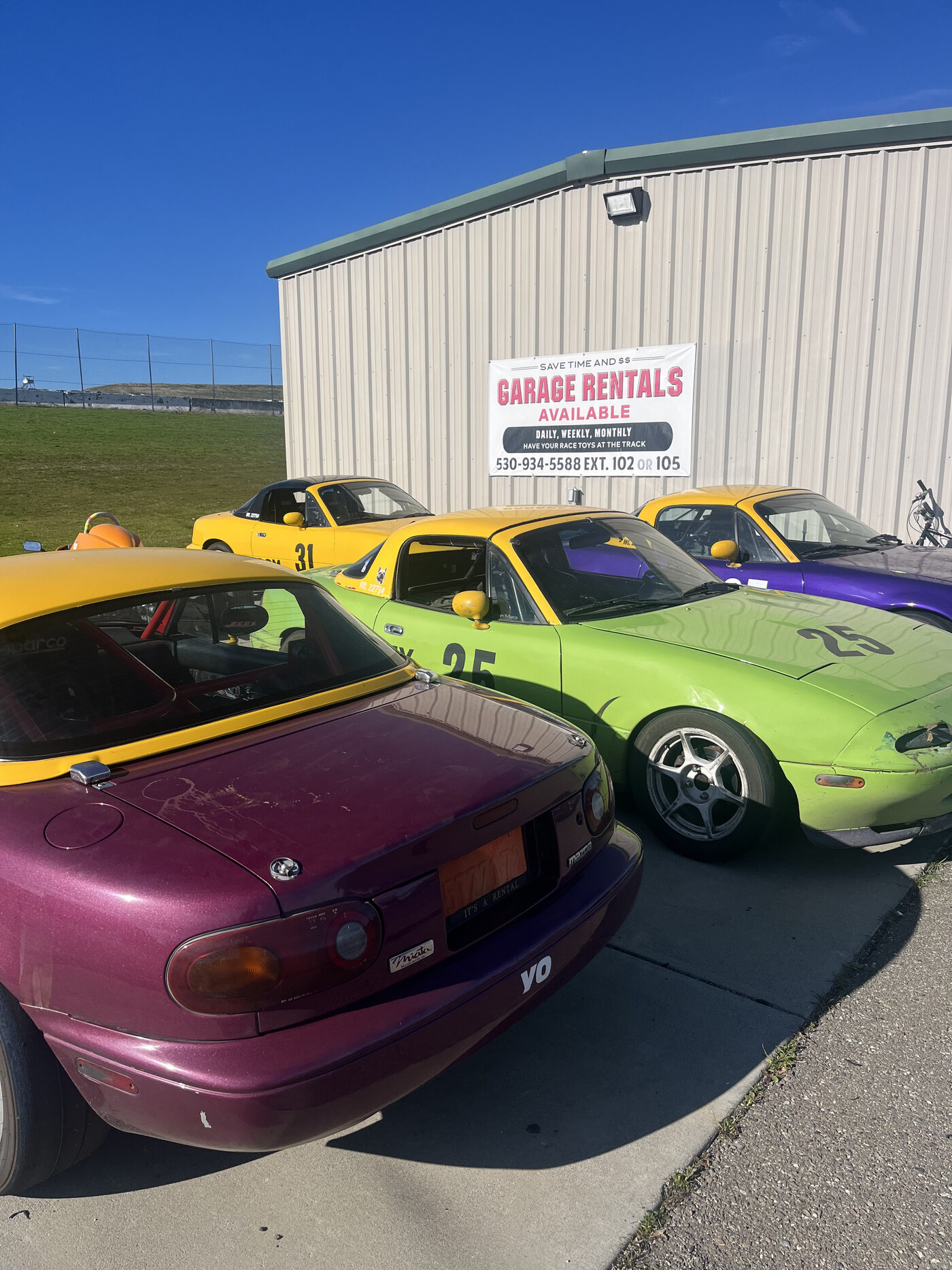 Fleet of Spec Miata rental cars parked at the track