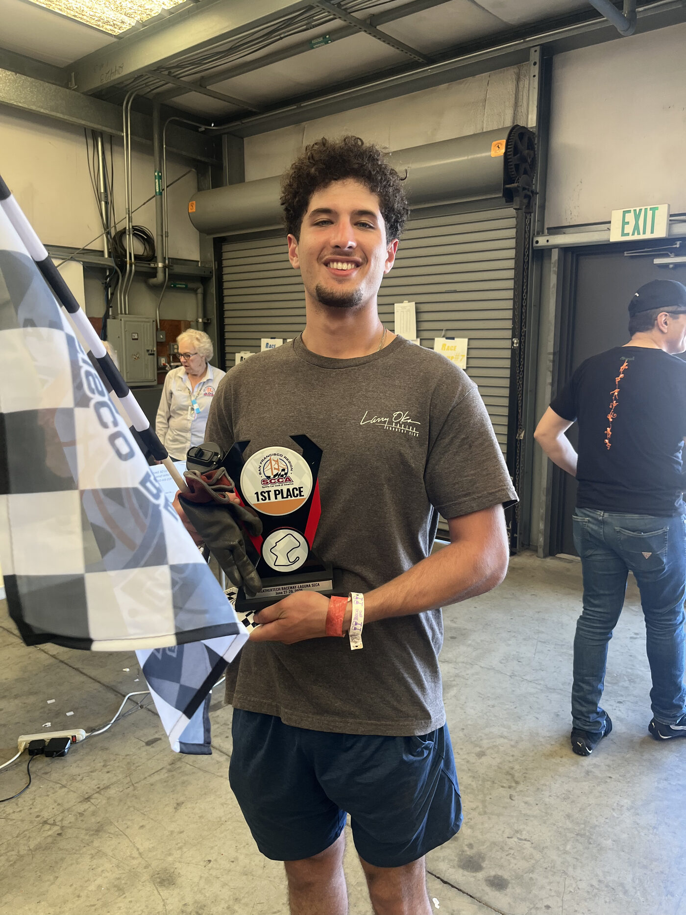 Driver holding a 1st place trophy at Laguna Seca